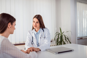 Female doctor talking with concerned patient.