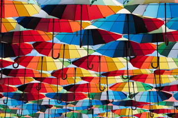 Colorful umbrella sky. Art installation of multi colored umbrellas over walking alley.