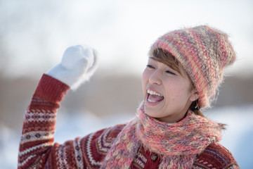 雪玉を持ち微笑む女性