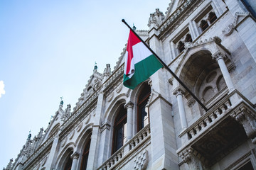 10.06.2019. Hungary, Budapest. Beautiful view of the main attraction of the city Parliament. Architecture. National flag of Hungary on a facade.