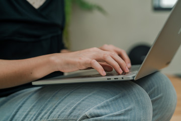 Closeup Asian beautiful woman Wearing a black shirt Sitting in the stairs in the house Use a laptop computer to work happily.