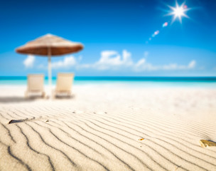 Summer background of beach with yellow sand and umbrella 