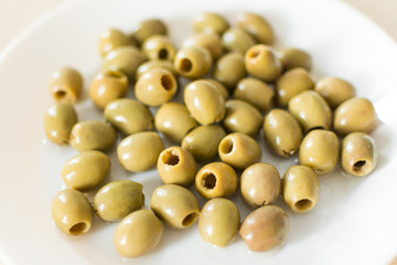 Pickled green olives in a plate on a white background. Olives, healthy eating. Italian cuisine.