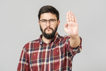 Fototapeta premium Portrait of serious bearded man showing stop gesture with his palm