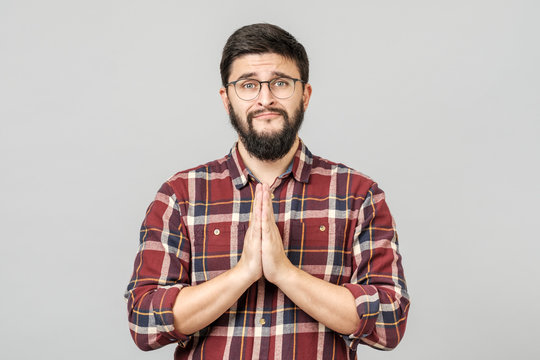 Cute attractive young man with begging expression and gesture