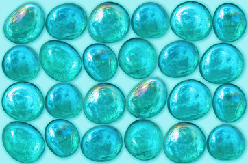 Glass pebbles on a light blue background.