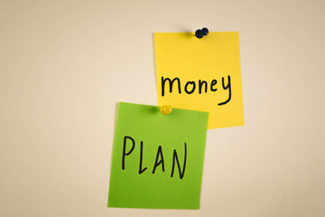 the word money on a piece of yellow paper among multicolored paper