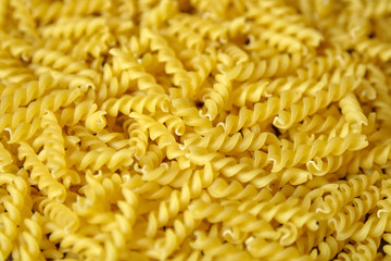 Heap of uncooked traditional italian spiral pasta pattern closeup