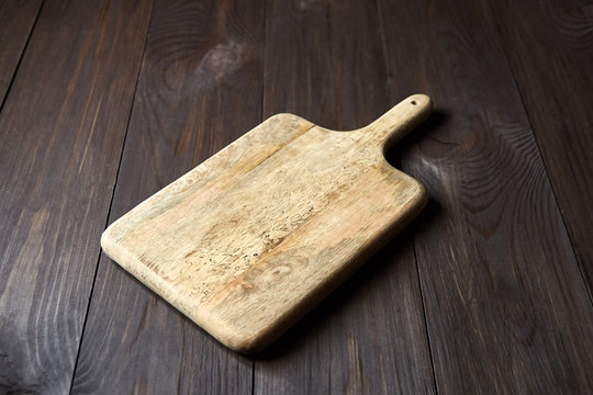 Empty cutting board from pine wood is on brown table