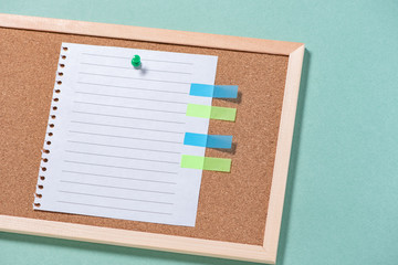 Corkboard for notes with empty sheets on buttons on a green background