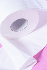 Eco-friendly white toilet paper on a pink background close-up