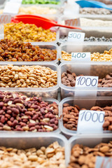 Nuts and dried fruits collection in the plastic boxes ready for sale on the marketplace in Belgrade. Close up