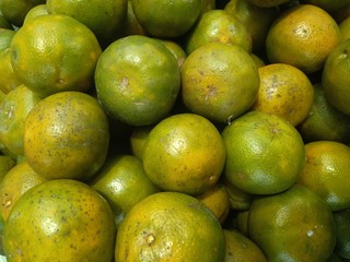 A lot of the green orange fruit in supper market, food background texture concept