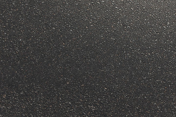 Asphalt road texture with small stones on sunset. Dark textured background. Empty with copy space.