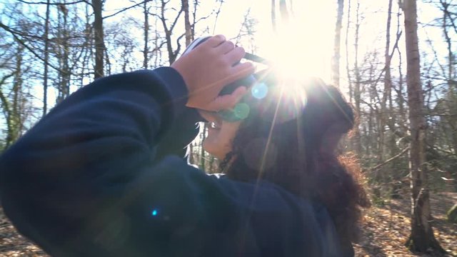4K video clip of beautiful mixed race African American girl teenager female young woman using virtual reality VR headset in a forest woodland environment