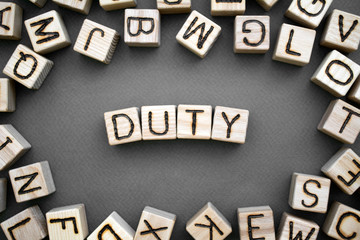 the word duty wooden cubes with burnt letters, duties of people, gray background top view,...