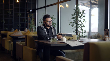 Man reading menu at table in cafe