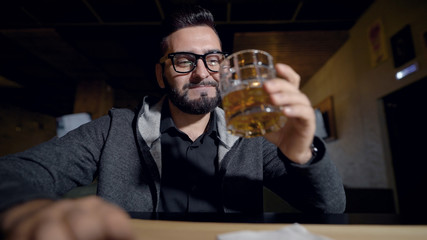Portrait handsome stylish guy in glasses with glass of whiskey, cheers in camera.