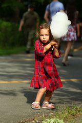 Fototapeta premium Emotional toddler girl not really wanting to share her cotton candy