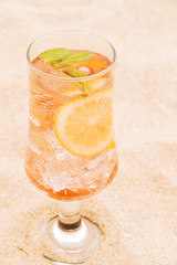 Glass of fresh orange drink with sliced citrus and mint