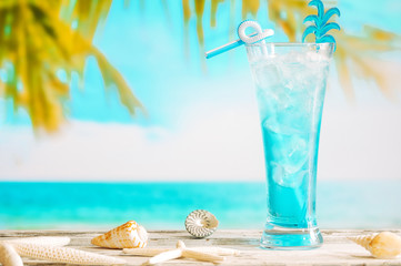 Glass of chilling blue drink and starfishes