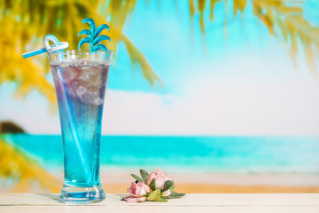 Glass of tasty blue drink and pink flower