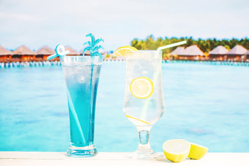 Glasses of fresh blue lemon drink with straw and sliced lime