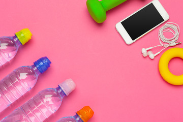 fitness concept with bottle of water, mobile phone with earphones