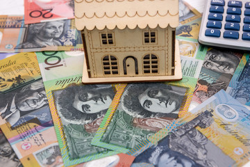 Calculator with wooden house model at australian dollars