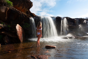 Female exploring and enjoying waterfalls and rock pools in nature