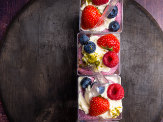 glasses of yogurt with berries, food closeup on wooden surface