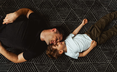 Smiling son playing with his father	