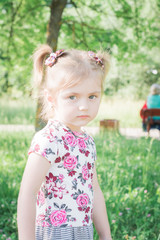 portrait of a little beautiful girl in a city park
