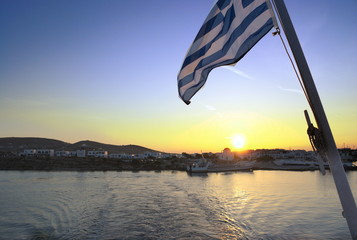 Greece, Paros. The sun sets over the neighbouring island of Antiparos. A balmy, still summer...