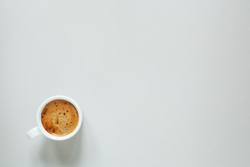 morning cup of coffee on light background, top view, copy space