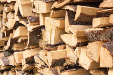 Wood for the village stove or fireplace stacked in a stack. Dry wood texture. Ecologically clean fuel. Selective focus.