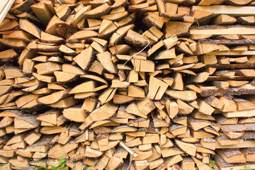 Wood for the village stove or fireplace stacked in a stack. Dry wood texture. Ecologically clean fuel. Selective focus.
