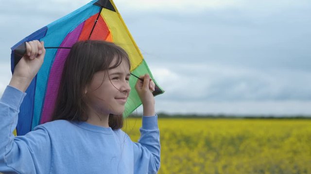 A child with a kite. Cute girl with colorful kite in nature.