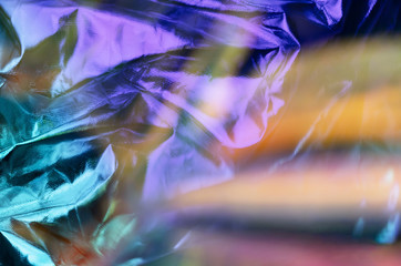 Modern beautiful holographic background of blurred crumpled foil. Trendy 80's style. Wallpaper design.