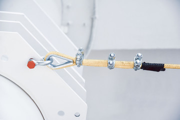 Close up of a yellow nylon rope fastening to a metal structure