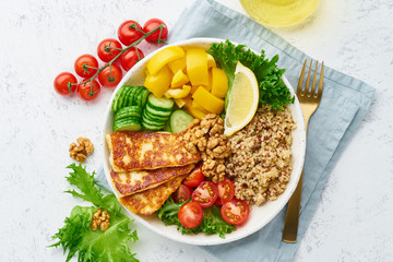 Buddha bowl with halloumi, quinoa, salad lettuce, balanced food, white background, top view