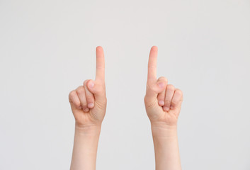 The index fingers of the child show the direction up