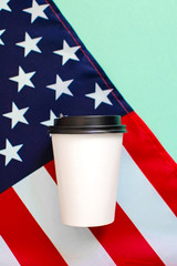 American flag and coffee paper cup on background.green
