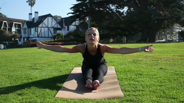 Young blonde woman is doing yoga exercises