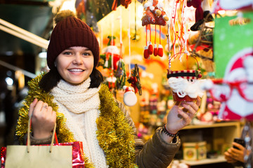 girl choosing Christmas decoration at market