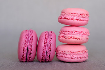 Stack of delicious french pink fruity flavour macarons on grey background