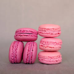 Stack of delicious french raspberry and blueberry flavour macarons on grey background