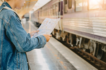 Man traveler reading a map on train station.