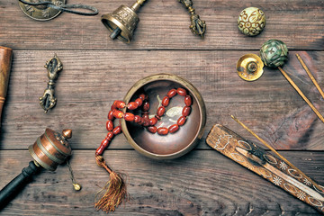 Copper singing bowl, prayer beads, prayer drum and other Tibetan religious objects for meditation