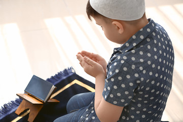 Little Muslim boy praying indoors